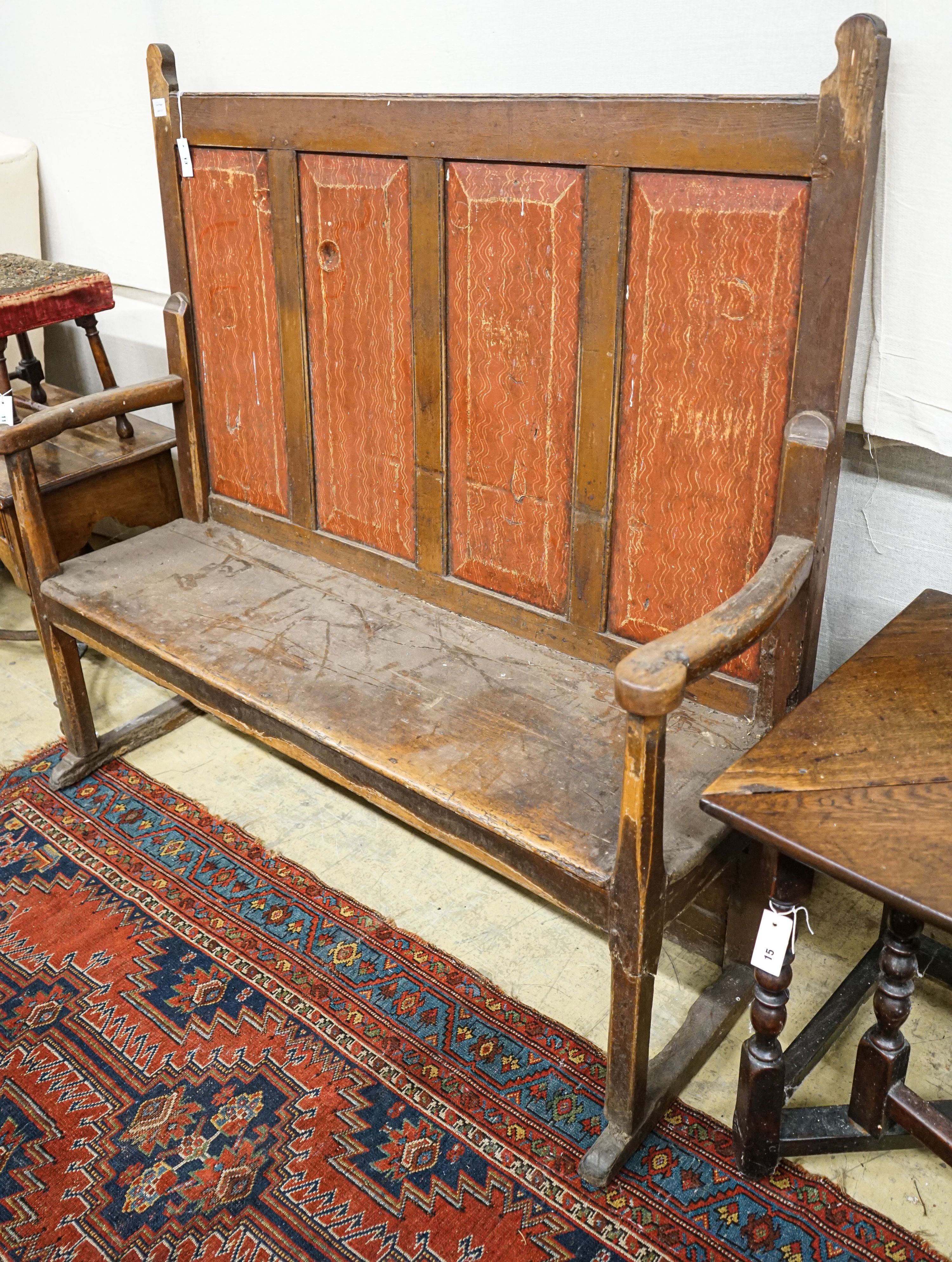 An early 19th century painted pine settle, with four panel back, scroll arms and solid seat, width 154cm, depth 49cm, height 145cm